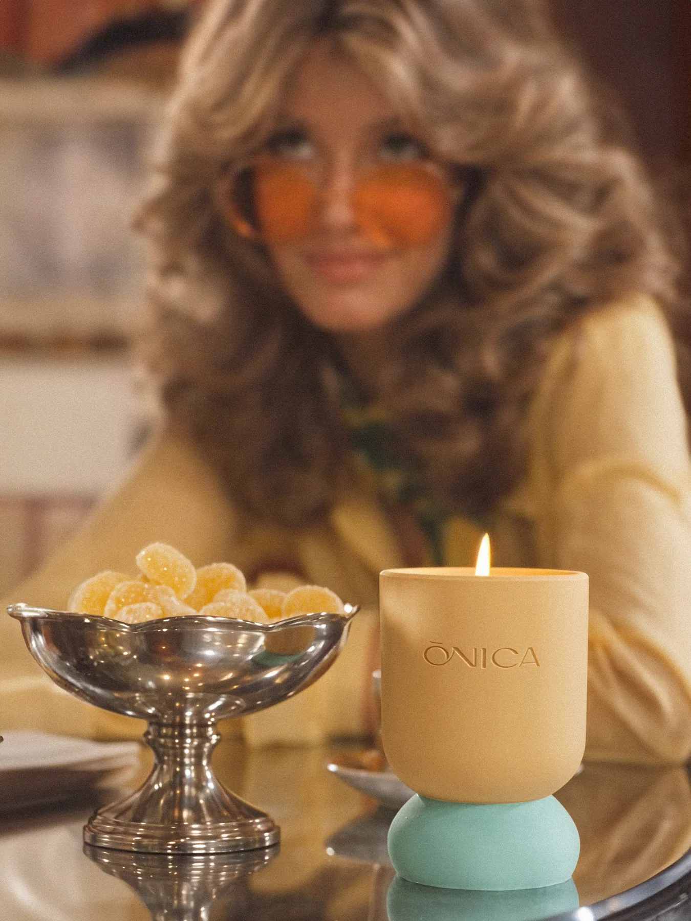 ONICA Bergamot Morning yellow candle styled with lemon sweets and a 1970s-inspired muse