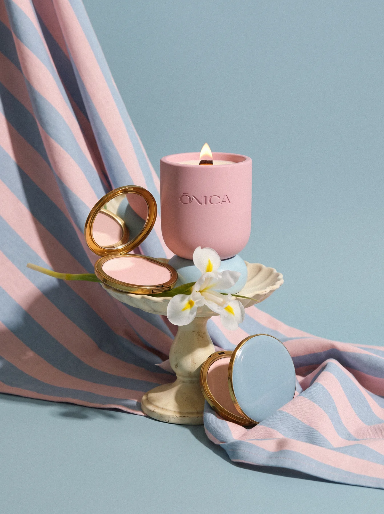 ONICA Musk Cloud sculptural pink and blue candle with vintage compacts and striped fabric